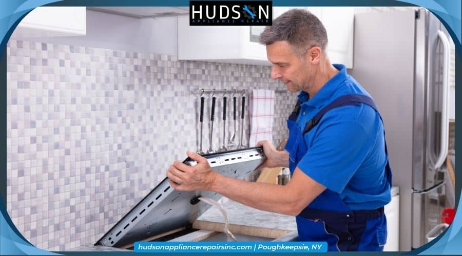 Technician in uniform standing in a kitchen.