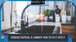 A frustrated homeowner looking into a jammed kitchen sink garbage disposal.